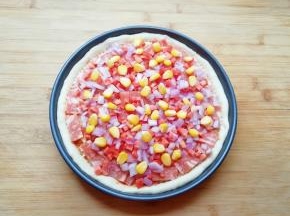 均匀的撒上洋葱、红萝卜和玉米粒。