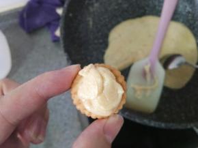 拿一块饼干用勺子挖一点牛轧糖放上