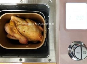 面包机桶内把搅拌叶拿出来，把腌制好的整只鸡放进面包机桶内