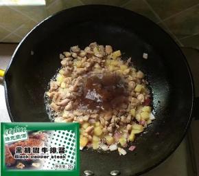 下之前滑炒好的鸡肉丁，翻炒均匀后加入黑椒酱。
