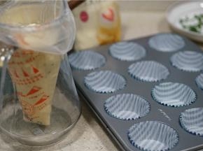 将蛋糕糊装入裱花袋中，再把纸托放在烤盘里。