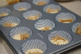 先挤半分满的蛋糊再纸托里，再加入一点肉松当夹心。再将蛋糊挤至纸托八分满。