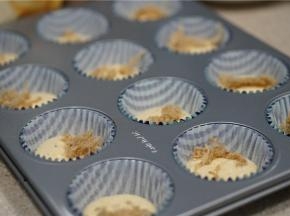 先挤半分满的蛋糊再纸托里，再加入一点肉松当夹心。再将蛋糊挤至纸托八分满。