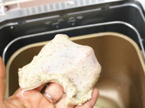 除黄油外，将面团中的其它原材料放入面包桶中，启动一个揉面程序（10分钟），揉至能拉出厚膜。