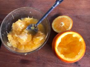 在橙子的蒂部切下一块成盖子，挖出果肉
