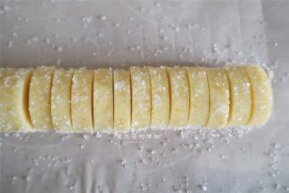 将粗砂糖铺在油纸上，滚几圈，让外圈全部沾满砂糖，