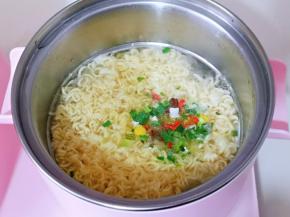 方便面的调料包倒入锅中，将方便面煮软捞出。