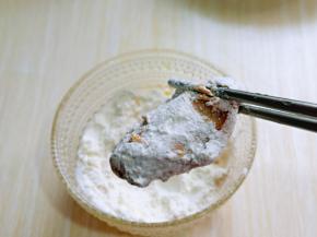 首先将腌制好的鸡翅均匀裹上玉米淀粉。