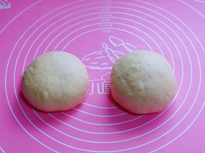 发酵好的面团分两个面团，盖上保鲜膜醒发10分钟。