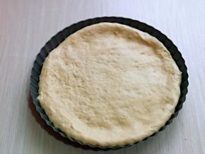 取一款面团用擀面杖擀圆饼，与自己的披萨盘一样大小即可。