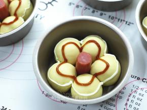 将发酵好的面团取出来，用沙拉酱和番茄酱挤出花型。