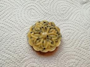 将搓好的小圆球放入月饼模具里面，压成带有花纹的芝麻核桃酥。