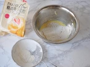 将低粉过筛入蛋黄糊中，用手动打蛋器搅拌至粉末消失即可。注意要选用低筋面粉，这样在搅拌时才不容易起筋。拌面粉是要注意手法，不要来回晃，要顺时针方法拌匀。