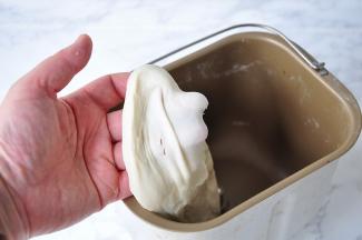 等面团揉至光滑加入黄油，再次揉至黄油吸收，轻拉面团可见稍厚的手套膜。因为这次的贝果的液体量偏少，所以揉出手套膜要困难点，我们也不需要。