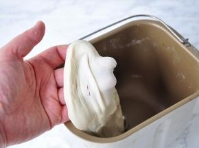等面团揉至光滑加入黄油，再次揉至黄油吸收，轻拉面团可见稍厚的手套膜。因为这次的贝果的液体量偏少，所以揉出手套膜要困难点，我们也不需要。