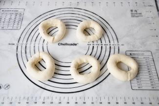 将擀扁的一端包住另一端捏紧，收口朝下放在油纸上。全部做好后放烤箱发酵30分钟，约1.5倍大即可