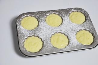 模具提前刷一下黄油，然后撒上一层薄薄的面粉，最后将蛋黄糊取出，分装在模具中，这个模具的量正好能装6个的量。装入面糊时记得到要八分满。