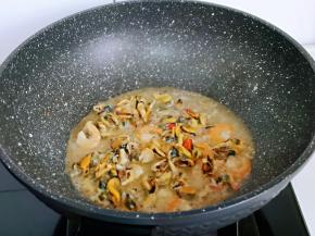 加入一汤勺纯净水，中小火将海虹肉与虾干炒熟。