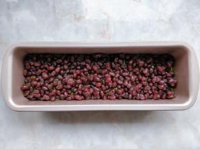 将抹茶磅蛋糕糊装入剪口裱花袋，均匀挤入模具中，表面密密的撒一层蜜豆。