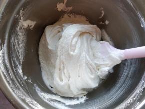 将蛋白糖霜分两次倒入糖粉和杏仁粉混合物中，轻柔翻拌，再刮压均匀。此时提起刮刀，面糊呈片状落下，落下的痕迹不会很快消失，表面有光泽，组织无大气孔。