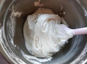 将蛋白糖霜分两次倒入糖粉和杏仁粉混合物中，轻柔翻拌，再刮压均匀。此时提起刮刀，面糊呈片状落下，落下的痕迹不会很快消失，表面有光泽，组织无大气孔。