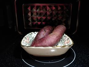 将紫薯洗净，放入浅盘中，盘里加少许冷水，入微波炉中火加热3分钟，翻转一下再加热2分钟左右，捏一下紫薯感觉芯软了，就熟透了。