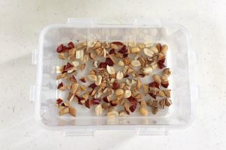 红枣洗净擦干，用刀把红枣切碎，预留一点红枣碎，其余和核桃碎以及花生仁一起放入保鲜盒内。（保鲜盒要耐高温或可加热的）