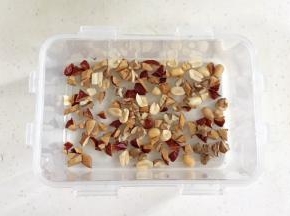 红枣洗净擦干，用刀把红枣切碎，预留一点红枣碎，其余和核桃碎以及花生仁一起放入保鲜盒内。（保鲜盒要耐高温或可加热的）