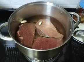 锅里放入足量水、盐、料酒、姜片、蒜煮开后放入牛肉煮25分钟