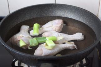 凉水下鸡腿，焯水。 焯水时水里放2片姜、2段葱。