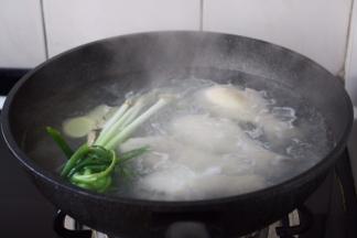 另外起锅，大火将水烧开，放入焯过水的鸡腿、小香葱、姜3片。