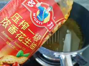 炸锅内倒入多力浓香花生油加热。