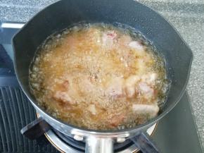 油温烧至6–7成热时，把腌制好的排骨下入锅中开始炸制。