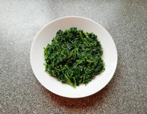 将炒好的草头盛在盘子里。