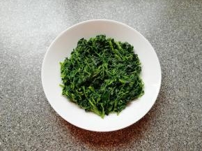 将炒好的草头盛在盘子里。