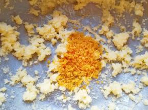 加入橙皮屑用刮刀翻拌均匀(橙子皮用工具擦出橙皮屑，然后去皮留出四瓣橙子果肉做装饰，剩下的橙子果肉切成小块备用)。