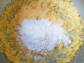 低筋面粉和泡打粉提前混合均匀过筛，先将四分之一加入到黄油糊中，压拌至无大量干粉。