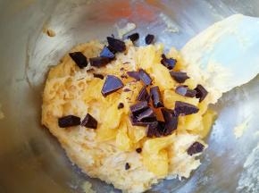 牛奶巧克力掰成小块，和橙子果肉一起加入到蛋糕糊里面，翻拌均匀。 