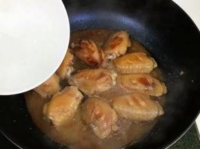 把鸡翅两面煎至金黄色，加入与鸡翅齐平的开水，稍搅动均匀。