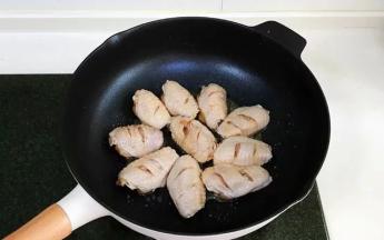 腌制好的鸡翅，用厨房纸吸干表面的水份，煎制时才能上色。开中火，不粘锅里倒入少许食用油，油热后放入鸡翅。