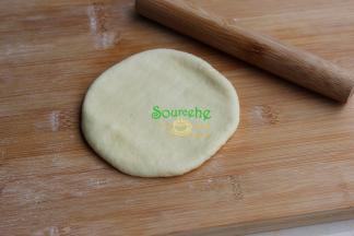 中间发酵好的面团，用手压扁，接着用擀面杖稍微擀薄，不要太薄。