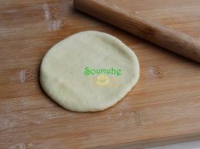中间发酵好的面团，用手压扁，接着用擀面杖稍微擀薄，不要太薄。