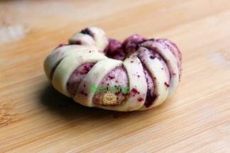 将面团翻过来，底面朝上，沿着长边卷起来。再将卷好的面团绕成圆形。首尾连接的地方要捏紧。