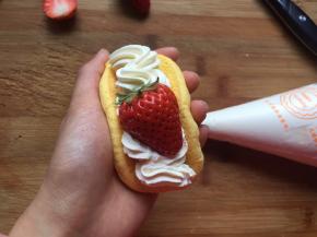 再挤一层奶油，放上一瓣草莓即可