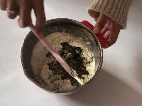 将混合过筛的杏仁面粉加入已打发的黄油中，用刮刀微微切拌。