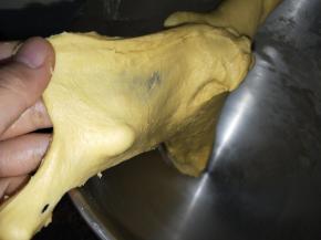 安装和面钩，揉至扩展状态，可以拉出厚膜，加入软化的黄油。