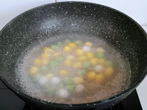 这时加入彩色圆子，中火煮，用勺子不断搅拌。