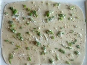 均匀刷玉米油，均匀撒适量干粉，均匀撒0.5克盐，均匀撒白芝麻，均匀撒葱花