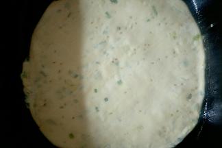 平底锅倒少许玉米油，把饼放入，在饼面再刷一层玉米油，开中火烙制。