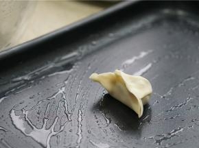 多用锅的煎盘刷一层薄油，将包好的饺子码放在上面。